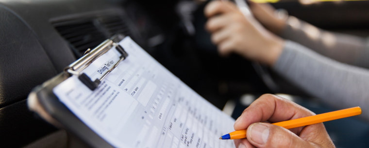 Examiner scoring a person taking their driving test.