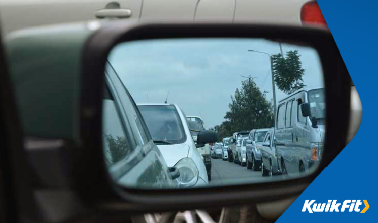 View of traffic in car wing mirror.