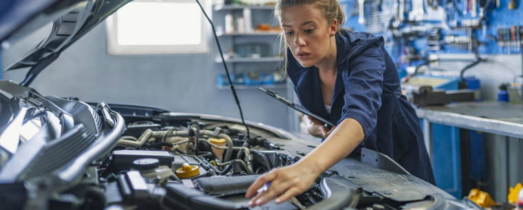 female technician servicing a car at a repair centre