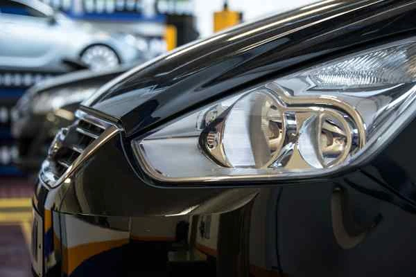Car headlights on a vehicle parked in a Kwik Fit garage