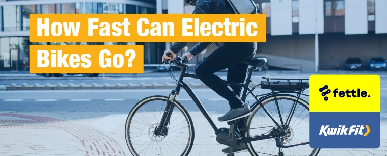 A person cycling through a city centre on an electric bike.