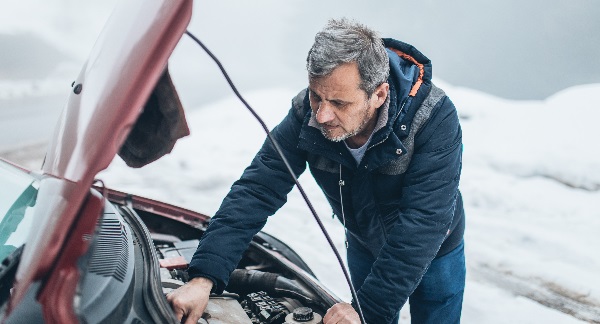 Man checking under bonnet of his car 