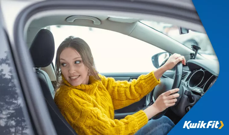 A drive carefully checks their mirrors while parallel parking.