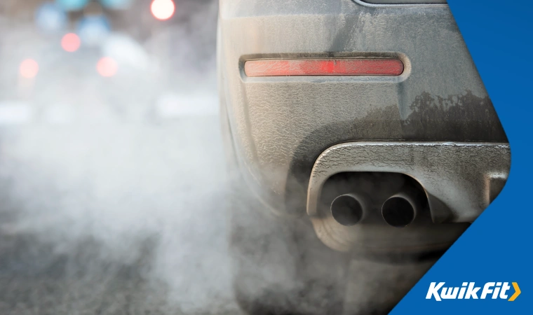 White smoke, likely condensation, coming out of a car's exhaust during cold weather.