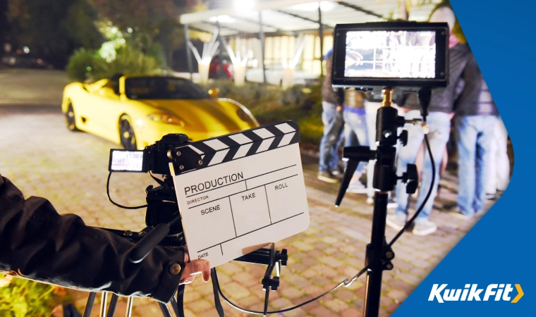 Movie production shooting with a yellow sports car,