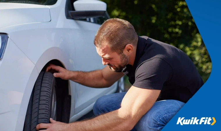 A person checking the quality of their car tyre.