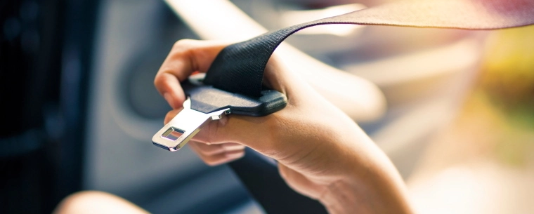 Person holding a seatbelt buckle