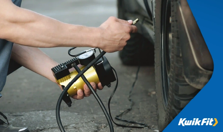 A person pumping up their car's tyre.