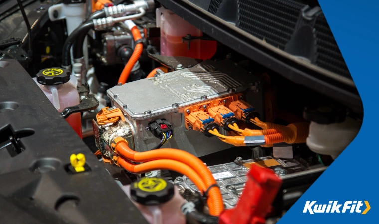 Under the bonnet of an electric car, a section of the batter can be seen with numerous heavy connectors attached.