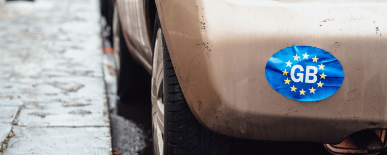 Worn GB sticker on the back of a dirty car